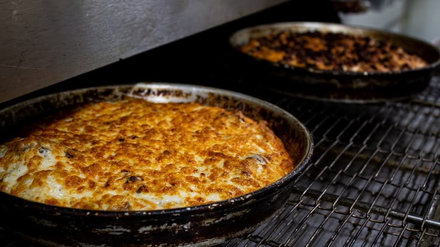 Pizzas coming out of the oven