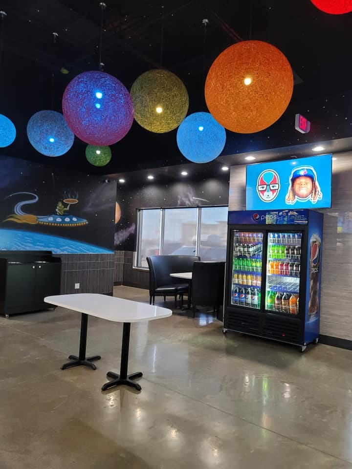 Inside UFO Pizza Edmonton: planet lamps and the flying-saucer mural